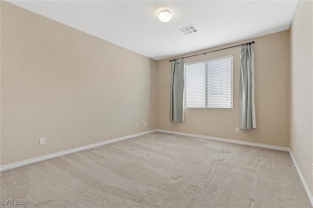 unfurnished room featuring light carpet