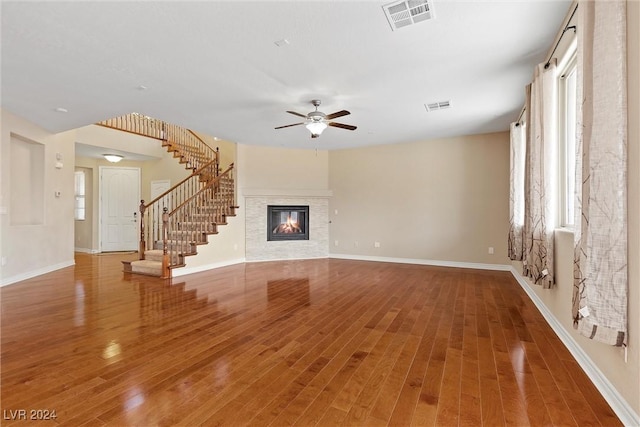 unfurnished living room with ceiling fan, a healthy amount of sunlight, and hardwood / wood-style floors