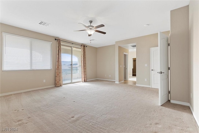 carpeted spare room with ceiling fan