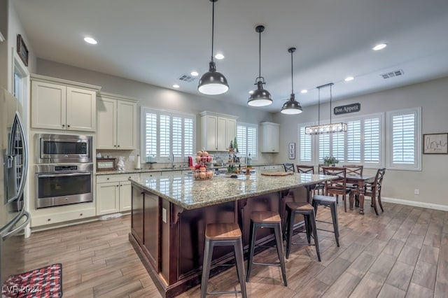 kitchen featuring pendant lighting, a center island, a breakfast bar area, and appliances with stainless steel finishes