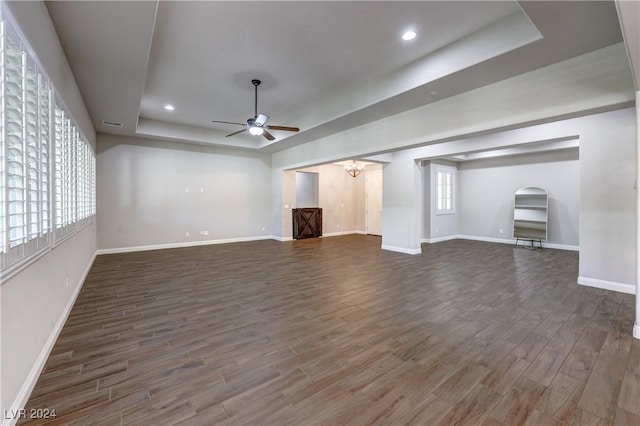 8351 Agave Bloom St, Las Vegas, NV 89131 - unfurnished living room with a raised ceiling, ceiling fan, baseboards, dark wood finished floors, and a chandelier