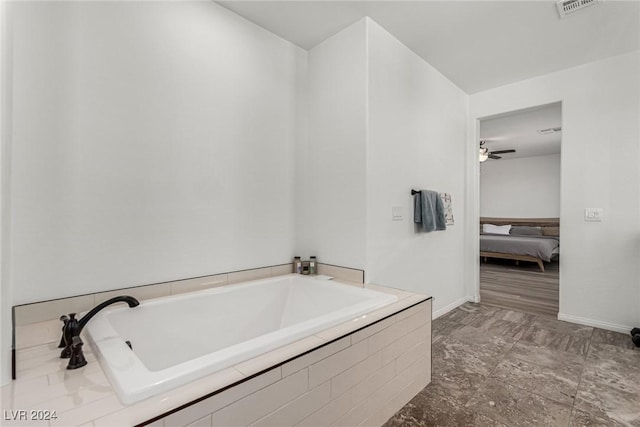 bathroom featuring a relaxing tiled tub and ceiling fan