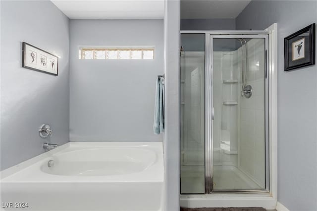 bathroom featuring shower with separate bathtub