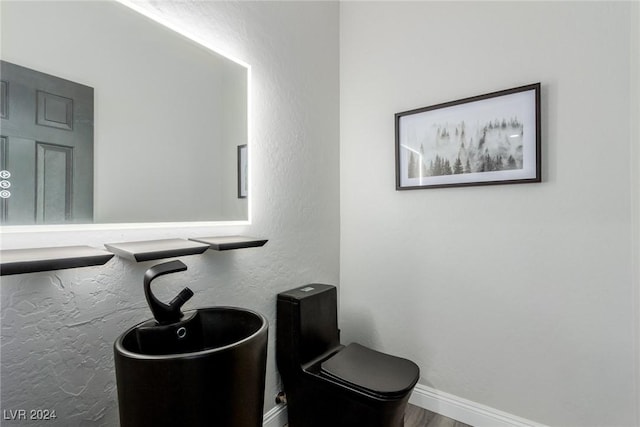 bathroom featuring hardwood / wood-style floors and toilet