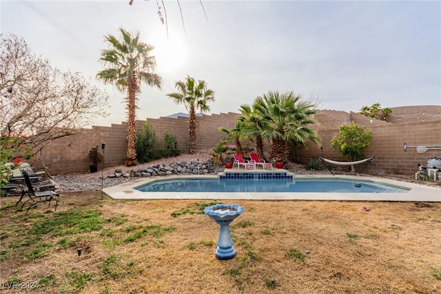 view of pool with a lawn