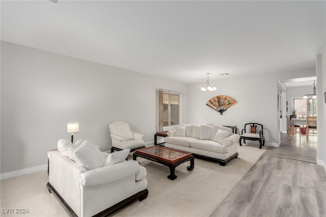 living room with light hardwood / wood-style flooring and a notable chandelier