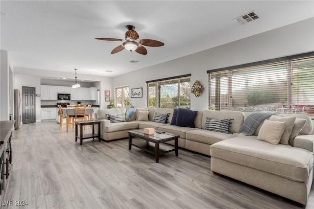 living room featuring ceiling fan and light hardwood / wood-style floors