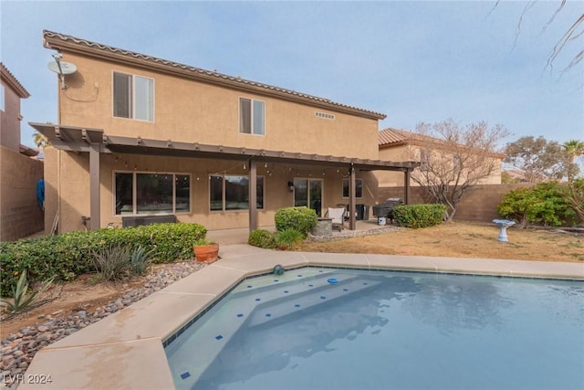 rear view of house with a pergola, a fenced in pool, and a patio area