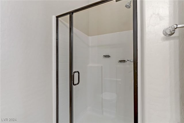 bathroom featuring a shower with shower door