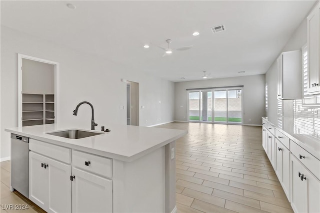 kitchen featuring white cabinetry, dishwasher, sink, ceiling fan, and an island with sink