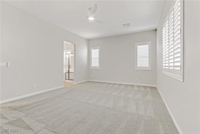 unfurnished room with light carpet, ceiling fan, and a healthy amount of sunlight