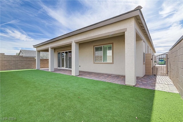 rear view of house featuring a patio and a lawn