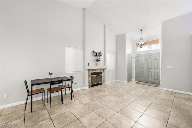 foyer featuring an inviting chandelier, baseboards, and high vaulted ceiling