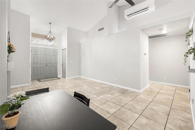 tiled foyer entrance with visible vents, baseboards, a chandelier, a wall unit AC, and high vaulted ceiling