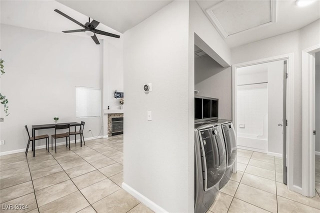 interior space with light tile patterned floors, independent washer and dryer, lofted ceiling, and baseboards