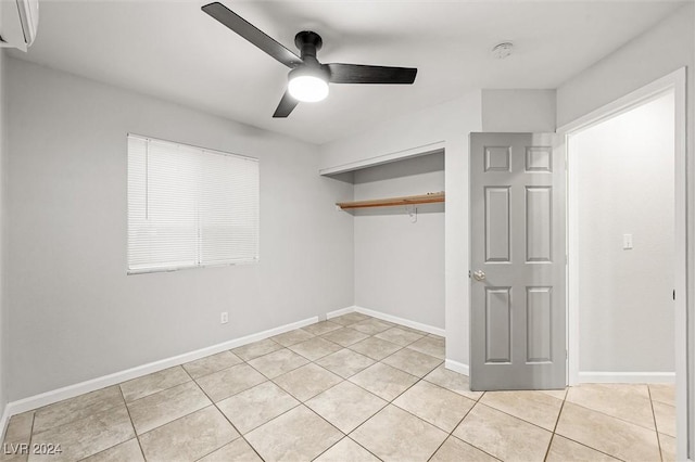 unfurnished bedroom with ceiling fan, baseboards, a closet, light tile patterned flooring, and a wall mounted AC