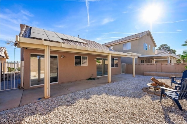 back of property with stucco siding, an outdoor fire pit, a patio, and fence