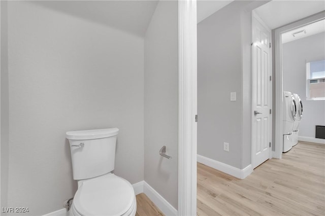 bathroom featuring hardwood / wood-style floors, washer and dryer, and toilet