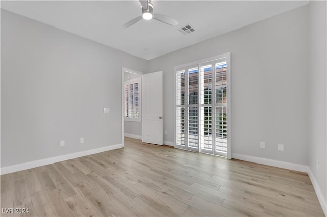 empty room with ceiling fan and light hardwood / wood-style flooring