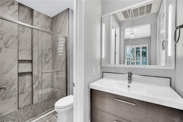 bathroom featuring vanity, toilet, and a shower with door