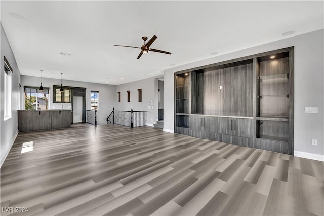 unfurnished living room with hardwood / wood-style floors and ceiling fan