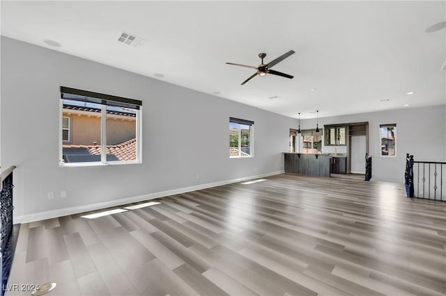 unfurnished living room with ceiling fan and hardwood / wood-style floors