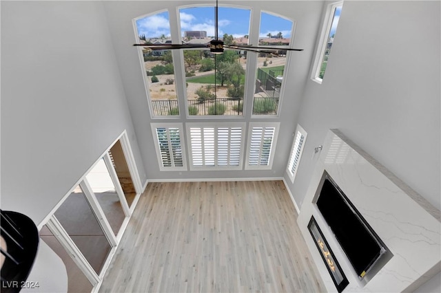 living room featuring a high ceiling and light hardwood / wood-style floors