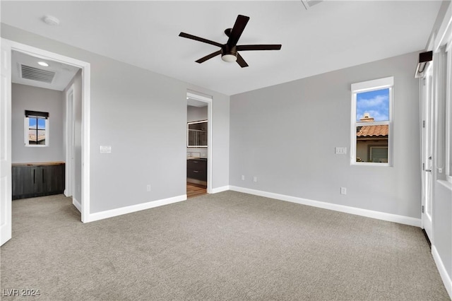 unfurnished bedroom with ceiling fan, carpet floors, and connected bathroom