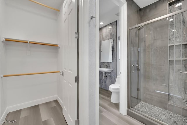 bathroom featuring sink, toilet, hardwood / wood-style floors, and walk in shower