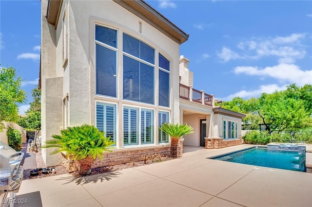 back of house with a patio, a balcony, and pool water feature