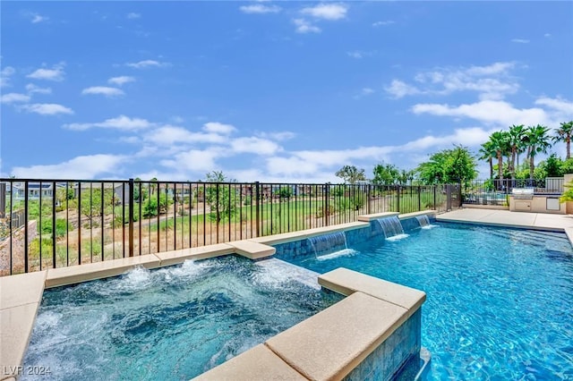 view of pool featuring pool water feature and a hot tub