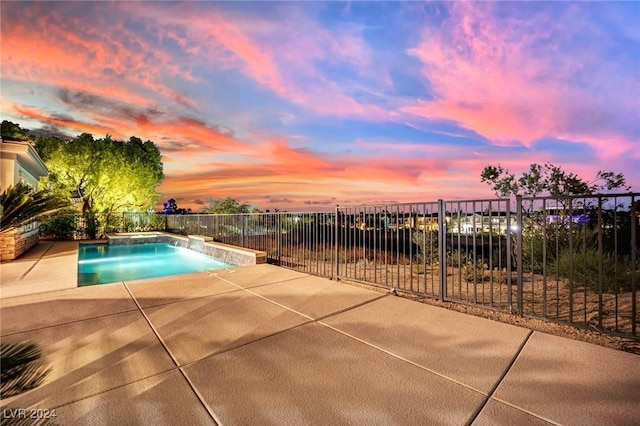 pool at dusk featuring pool water feature