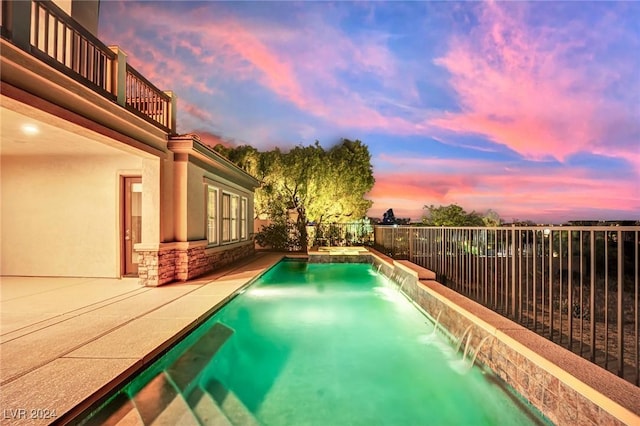 pool at dusk with pool water feature