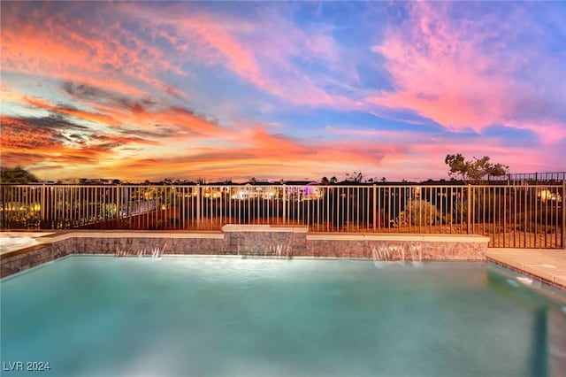 pool at dusk with pool water feature