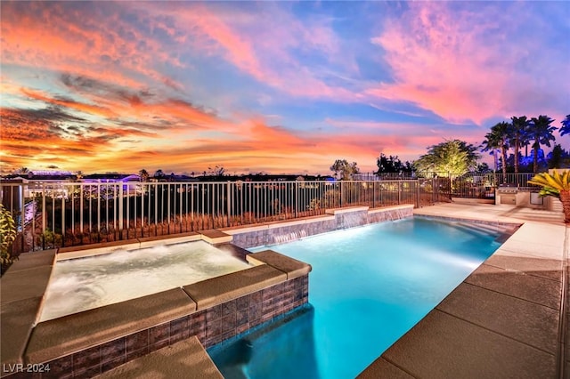 pool at dusk with an in ground hot tub and pool water feature