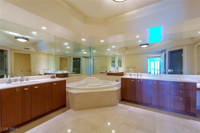 bathroom with tile patterned flooring, vanity, a bathtub, and a tray ceiling