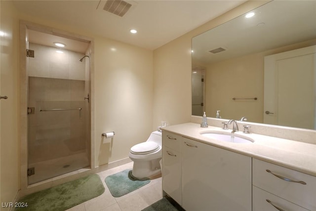 bathroom featuring tile patterned flooring, vanity, toilet, and a shower with door