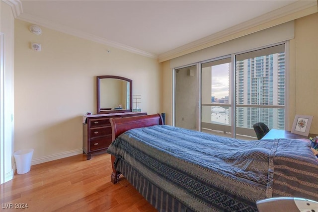 bedroom featuring ornamental molding and light hardwood / wood-style flooring