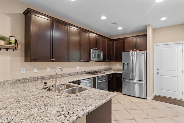 kitchen with dark brown cabinetry, sink, light stone counters, kitchen peninsula, and appliances with stainless steel finishes