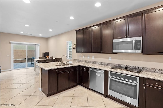 kitchen with kitchen peninsula, dark brown cabinetry, stainless steel appliances, and sink