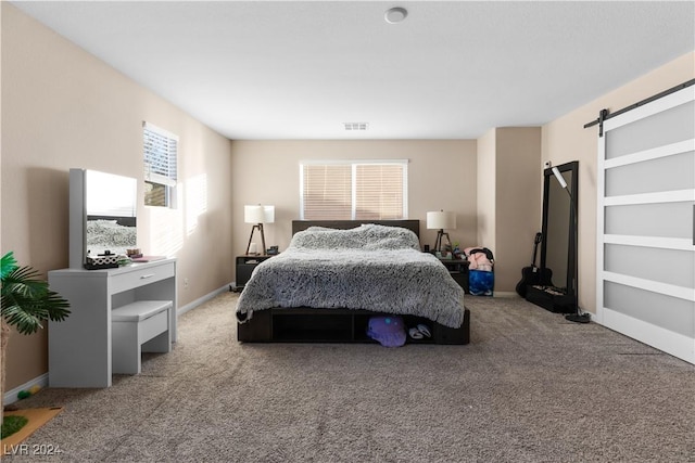 carpeted bedroom featuring a barn door