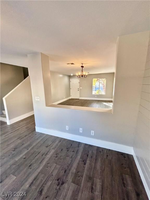 spare room featuring hardwood / wood-style flooring and a notable chandelier