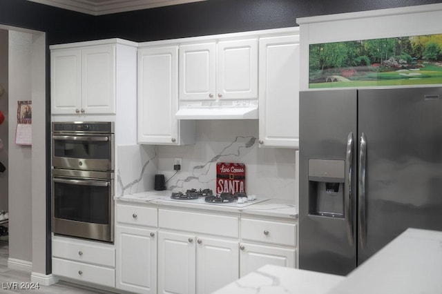 kitchen with stainless steel appliances, light stone countertops, white cabinets, and decorative backsplash