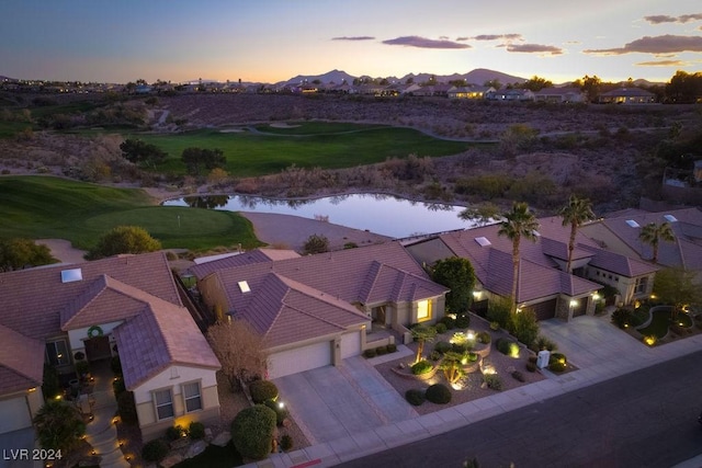 aerial view at dusk featuring a water and mountain view