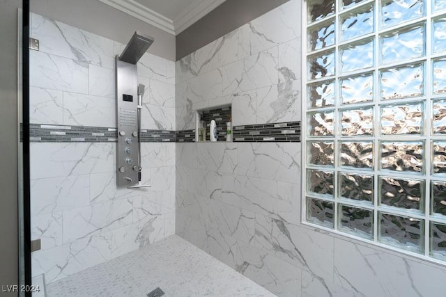 bathroom with ornamental molding and tiled shower