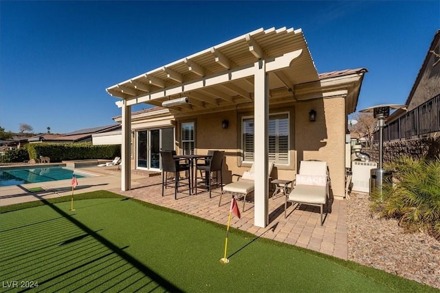 rear view of house featuring a fenced in pool and a patio area