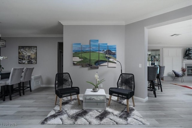 living area with ornamental molding and hardwood / wood-style floors