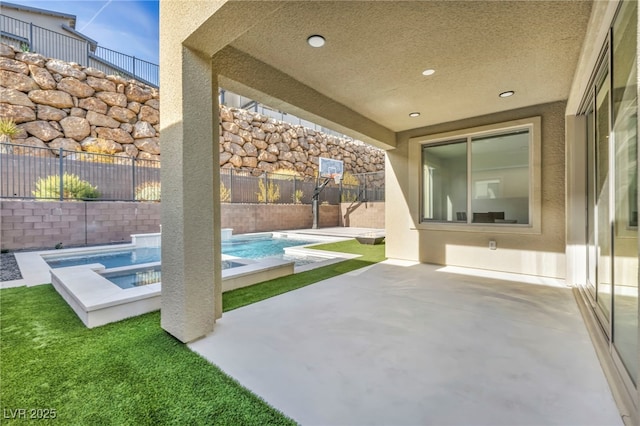 view of patio / terrace with a swimming pool with hot tub