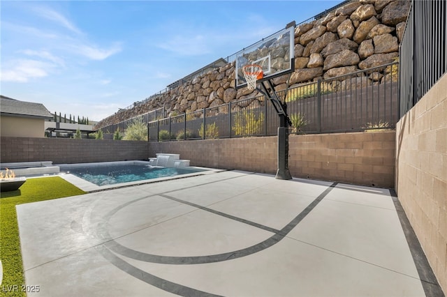 view of sport court with a fenced in pool and pool water feature