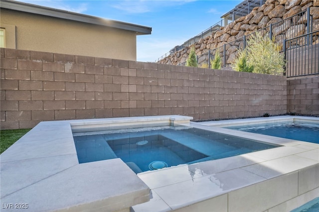 view of swimming pool with an in ground hot tub